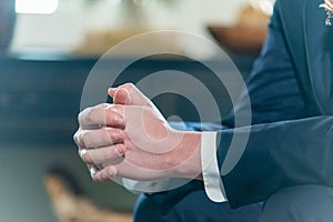 Shallow focus shot of the hands of the groom nervously waiting for the ceremony