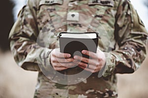 Shallow focus shot of a young soldier holding a bible