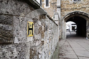 Shallow focus of a typical Hydrant yellow sign seen attached to a medieval wall.