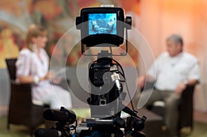 Shallow focus of a Video camera viewfinder, recording show in a TV studio during a talk show