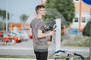 Shallow focus of a young male photographer filming an event outdoors