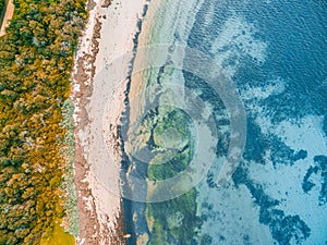 Shallow ocean water and rocky beach.