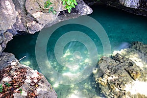 Shallow sea water surface shines through the bottom with stone and rock