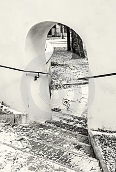 Shallow stairs and an historic gate with railing, colorless