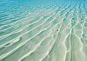 Shallow Turquoise Ocean Water with Sunlight Patterns on Sandy Seabed
