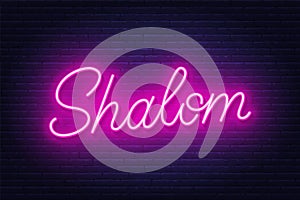 Shalom neon sign on brick wall background.