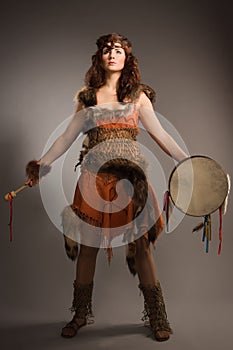 Shaman woman with a tambourine in studio
