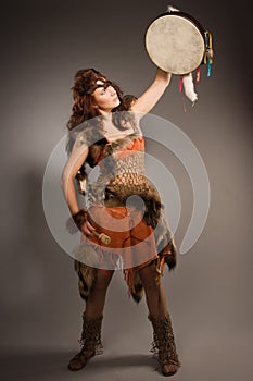 Shaman woman with a tambourine in studio