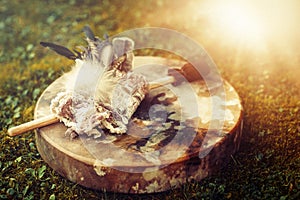 Shamanic drum and shamanic feathers on denim.