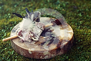 Shamanic drum and shamanic feathers on denim