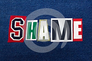 SHAME text word collage, colorful fabric on blue denim, guilt and blame concept