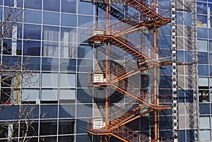 A shameful staircase running along the wall of a glass building