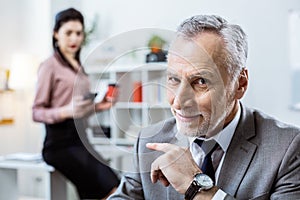 Shameless beaming old man pointing on dark-haired woman