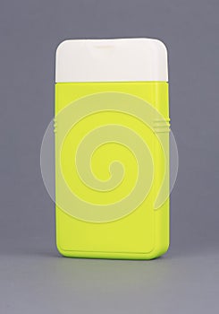 Shampoo bottle on grey background. Cosmetic container for liquid, lotion, bath foam. Beauty product package. Mock up