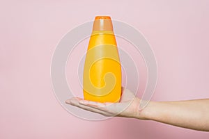 Shampoo bottle in hand. Spa beauty treatment and skin, body and hair care concept. Bath accessories