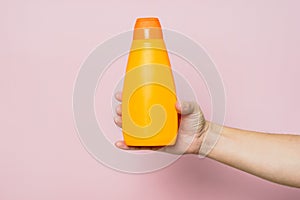 Shampoo bottle in hand. Spa beauty treatment and skin and hair care concept. Bath accessories
