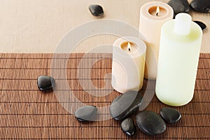 Shampoo bottle, massage stones and candles