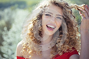 Shampoo concept. Curly hair. Woman holding curly hair on Spring background. Shampoo concept. Healthy hair. Beauty model