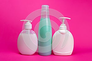 shampoo and liquid soap in a bottle with a dispenser on a pink background
