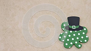 Shamrock with leprechaun hat laying on a tan background