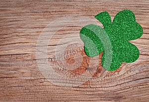 Shamrock over old wood background. Glitter Green Clover.