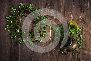 Shamrock wreath, shamrocks and silver pot on an old rustic wood background.
