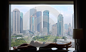 Woman in underwear poses on windowsill with photo