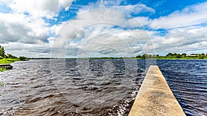 Shannon River with calm waters with a small pier and green vegetation