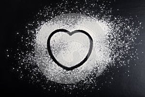 Shape of heart drawn on the flour on a black background