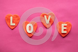Shape of heart, word LOVE in red hearts on pink background, Love icon, valentine`s day