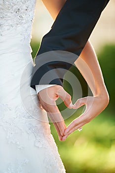 The shape of love. Cropped image of a newlywed couple making a heart with their hands.