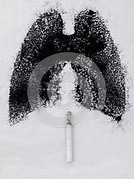 Shape of lungs with charcoal powder and cigarette on white background