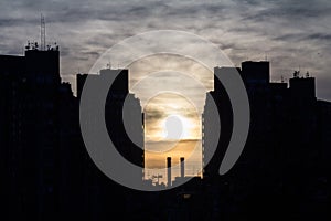 Shape of Traditional communist housing towers in the suburb of Belgrade, in New Belgrade with industrial chimneys at dusk.