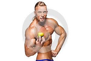 Shaped and healthy body man holding a e fruit