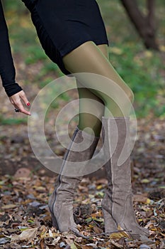 Shapely female legs are on the fall foliage