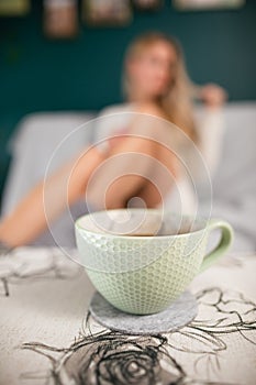 The shapely legs of a sexy girl. A cup of hot coffee.