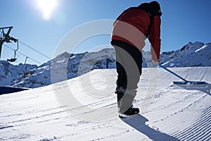 Shaper with a shapetool shaping a kicker in a snowpark in St.Anton