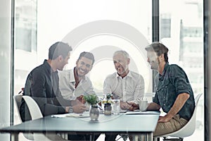 Shaping the company with new ideas. a group of businessmen having a meeting around a table in an office.