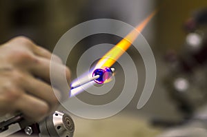 Shaping glass over a flame