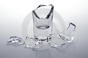 Shards of a broken glass stack on a white background.