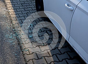 The shards lie under the car window after the thief robbed things. small pieces of safety shattered glass spill to ground when som