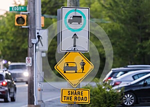 SHARE THE ROAD a road sign with a bicycle symbol informational for the traffic. Yellow Diamond Warning Sign