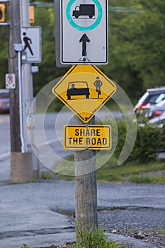 SHARE THE ROAD a road sign with a bicycle symbol informational for the traffic. Yellow Diamond Warning Sign