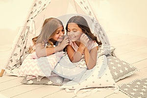 Share secrets concept. Girls cute children lay relaxing in teepee bedroom. Cute space for leisure. Modern interior