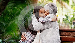 We share a special bond between us. an adorable little girl hugging her grandmother in the park.