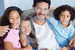 We share the strongest of family bonds. Portrait of a happy single parent family sitting on a sofa and smiling at the