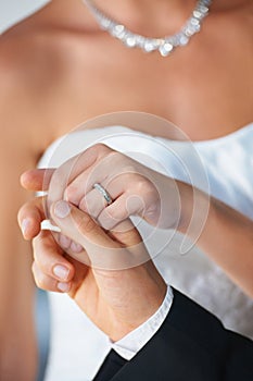 They share an unbreakable bond. Closeup of a groom leading his bride out of the chapel - Focus on Wedding Ring.