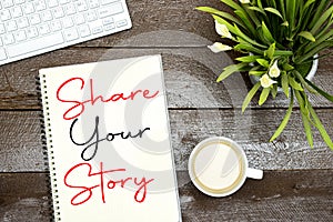 Share your story concept on notebook with cup of coffee and keyboard, lilies flowers