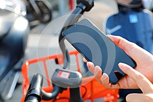 Shared bikes. Hand using smartphone scanning the QR code of shared bike in city