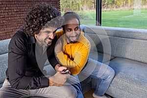 Shared Laughter: Two Friends Enjoying a Light-Hearted Moment on the Sofa